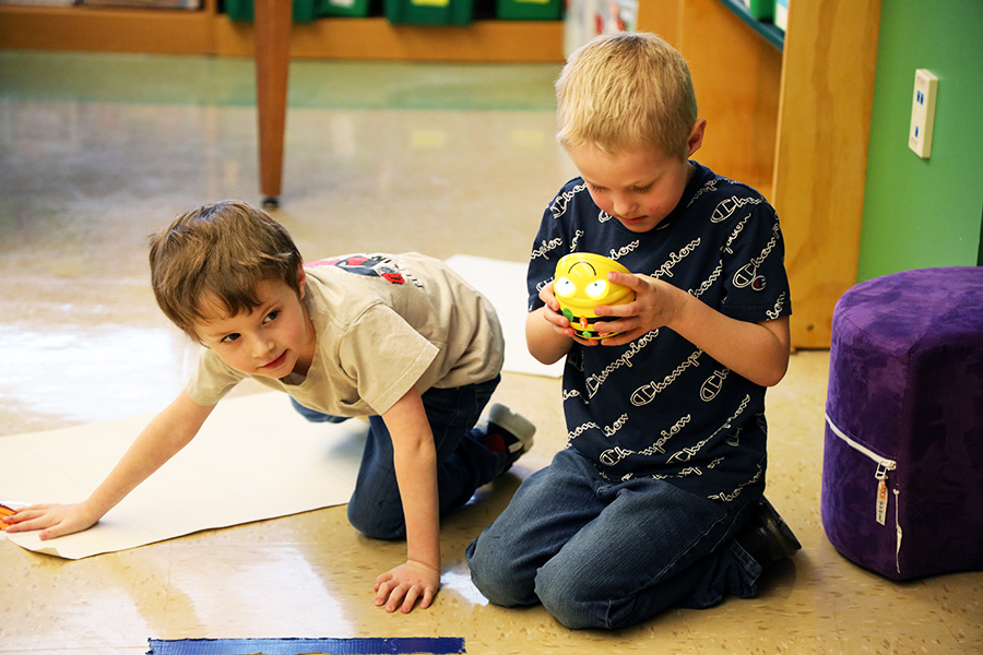 Image of two students taking part in a school activity on the floor. 