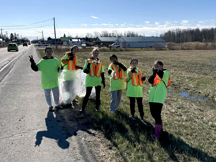 Image of students cleaning up the side of a roadway.