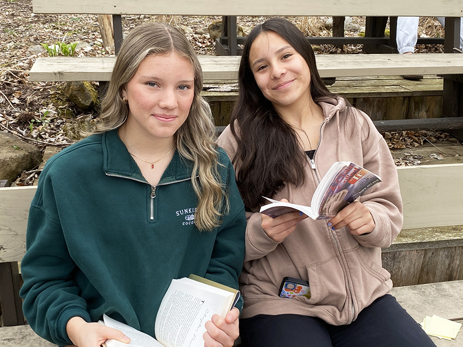 Image of students posing with books.