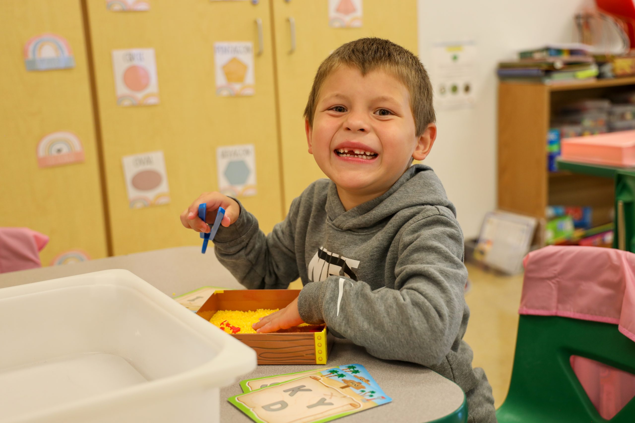 A student smiling while playing at a table