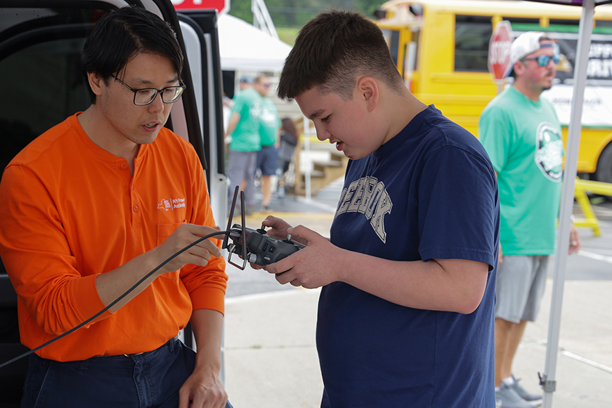 Student being taught how to fly a drone using the controller