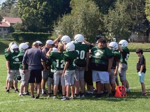 Young football players huddling on the field