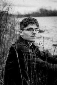 Image of teen sitting by a river