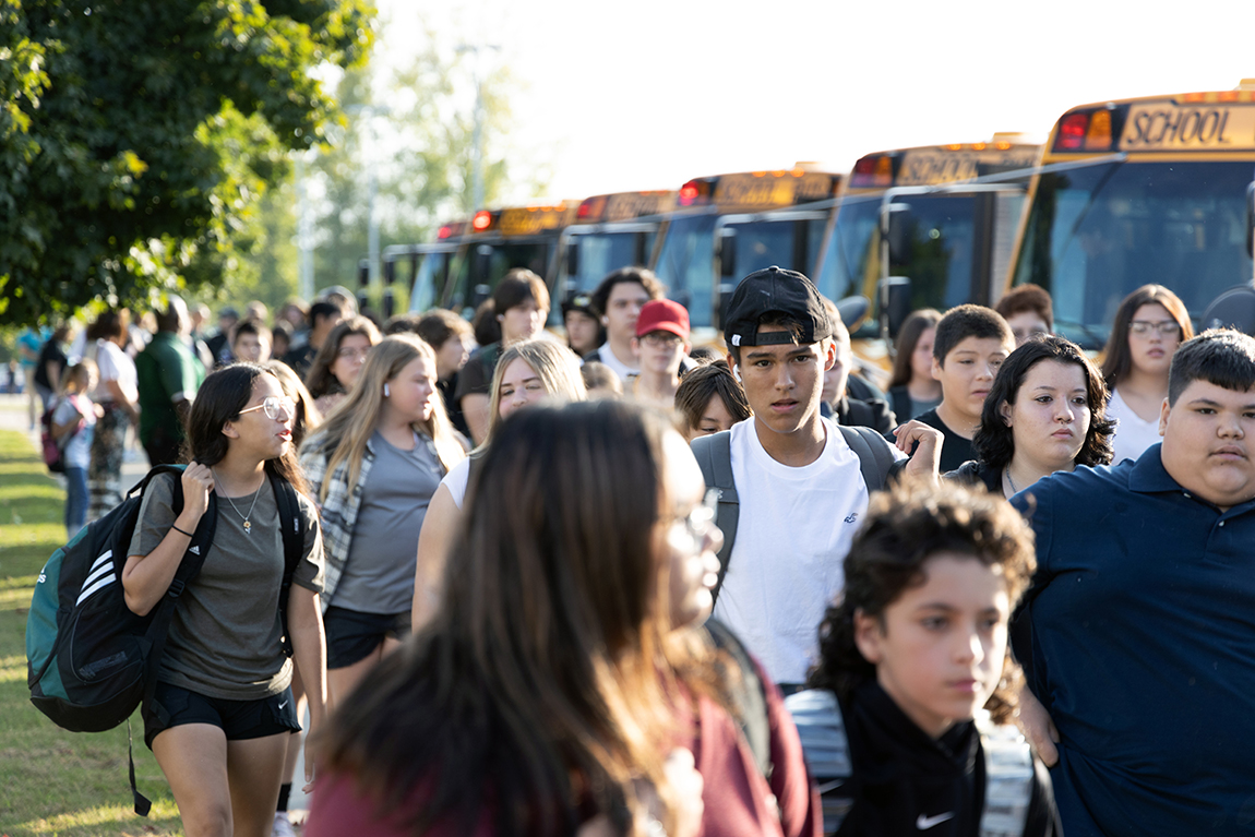 Image of high school crowd getting off buses