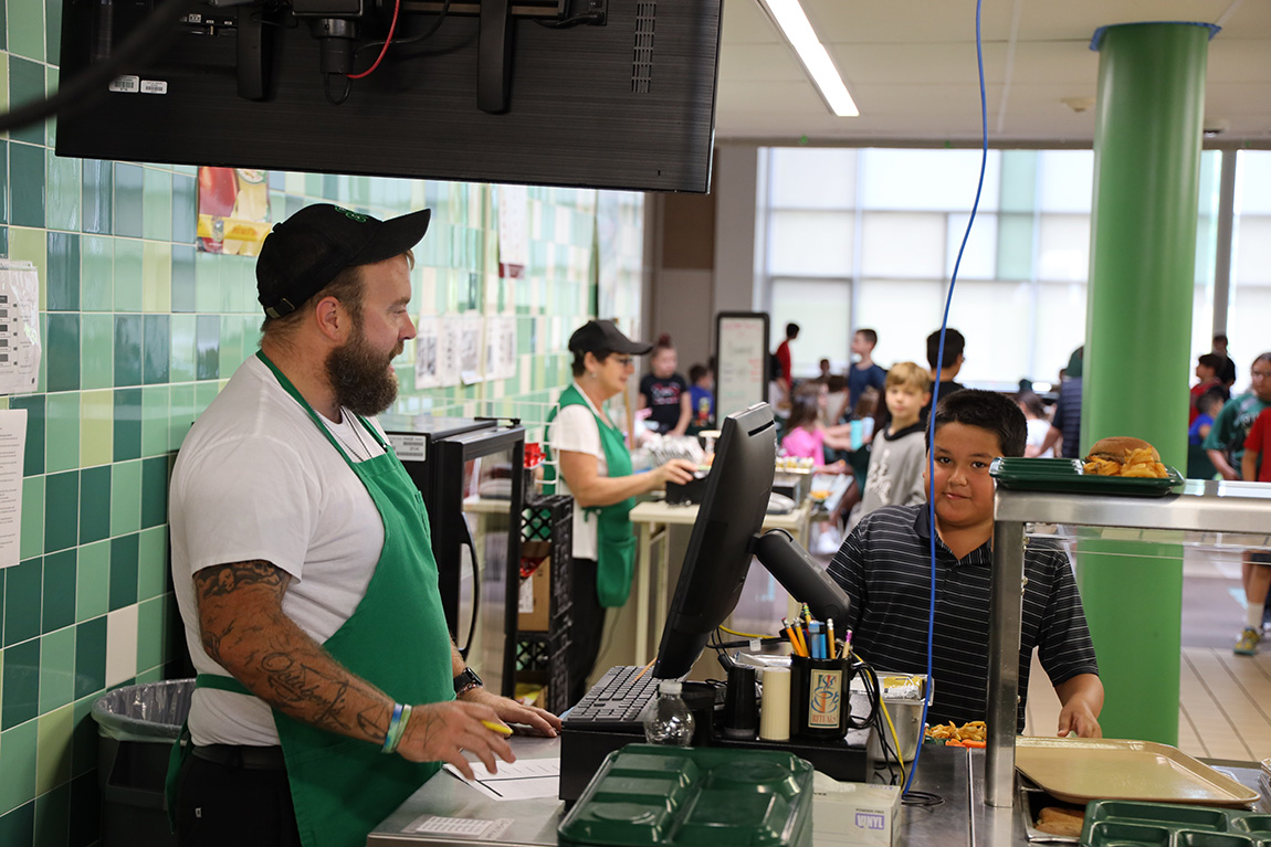 Image of cafeteria worker serving students
