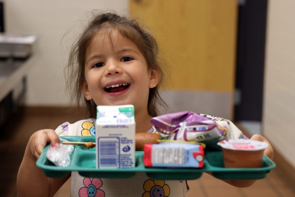 Image of a child holding a lunch tray